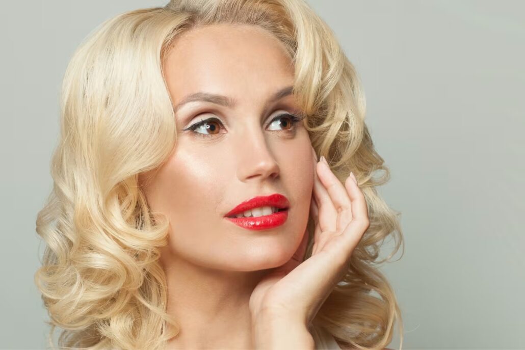 Woman with defined cheekbones and blonde hair, showcasing ideal results of cheek enhancement procedures.