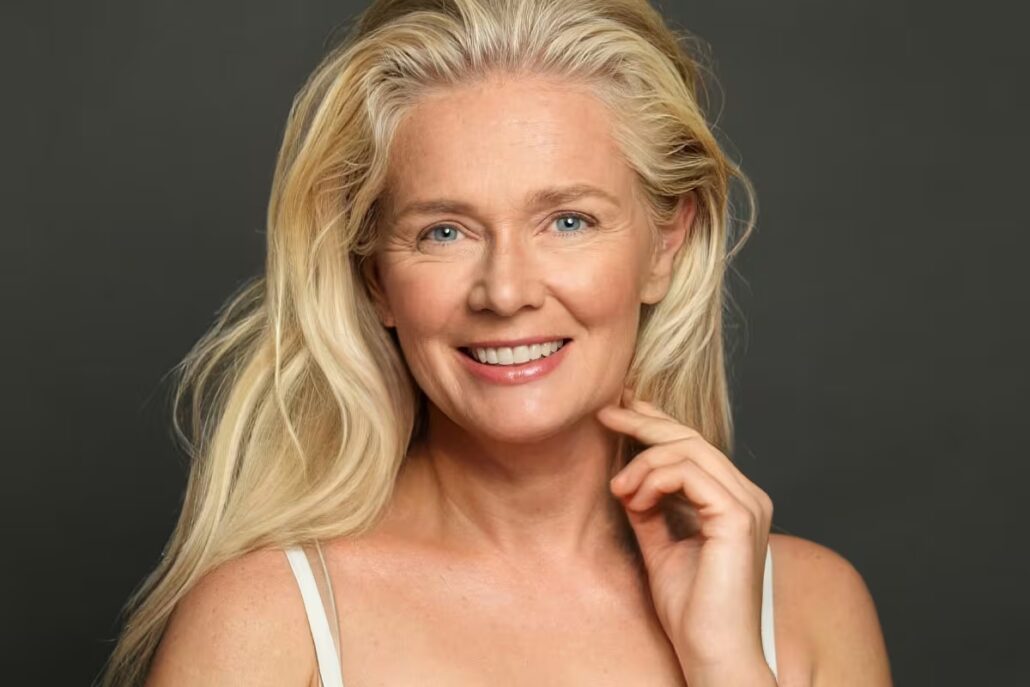 Smiling woman with bright eyes and youthful appearance after undergoing blepharoplasty surgery.